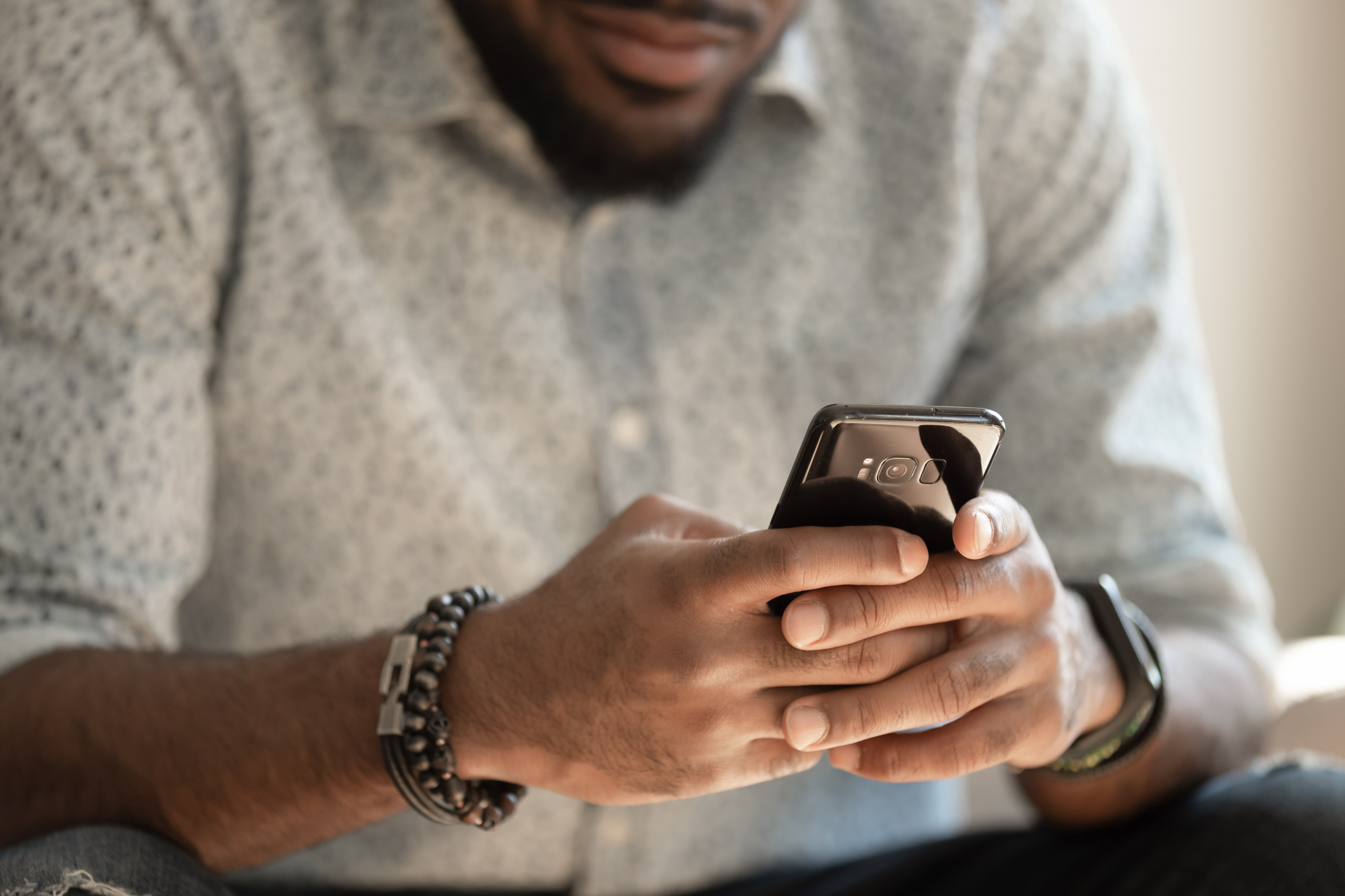 man scrolling on smart phone