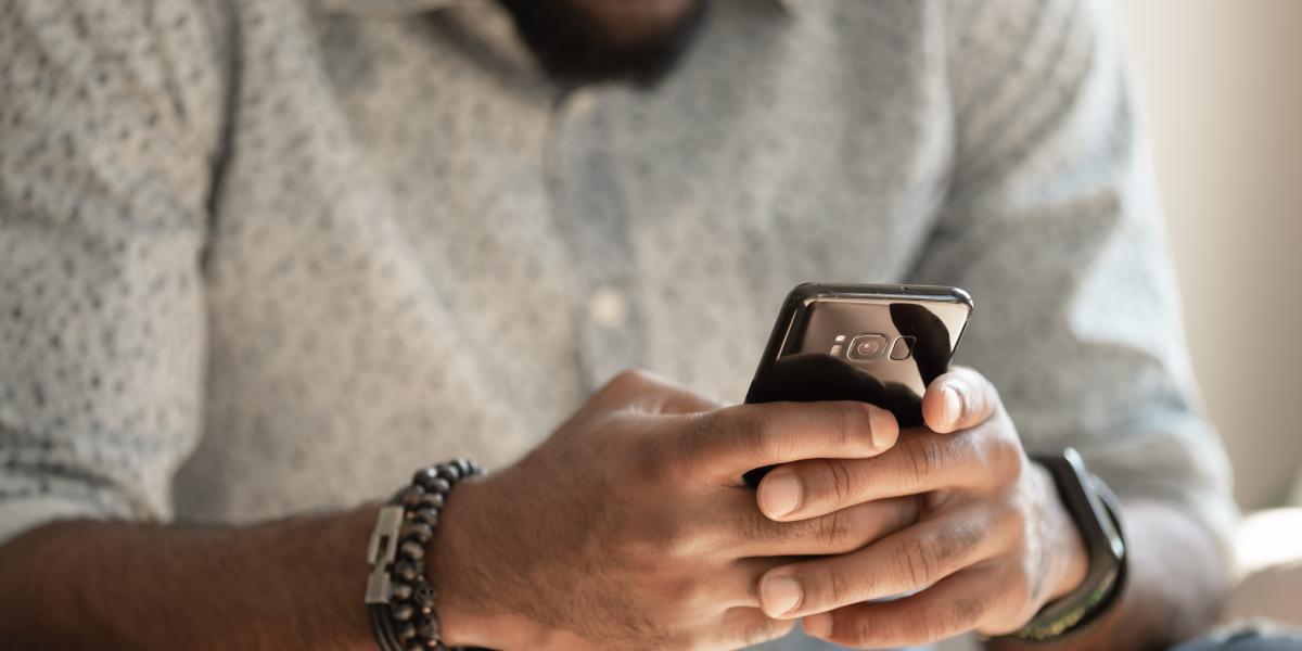 man scrolling on smart phone