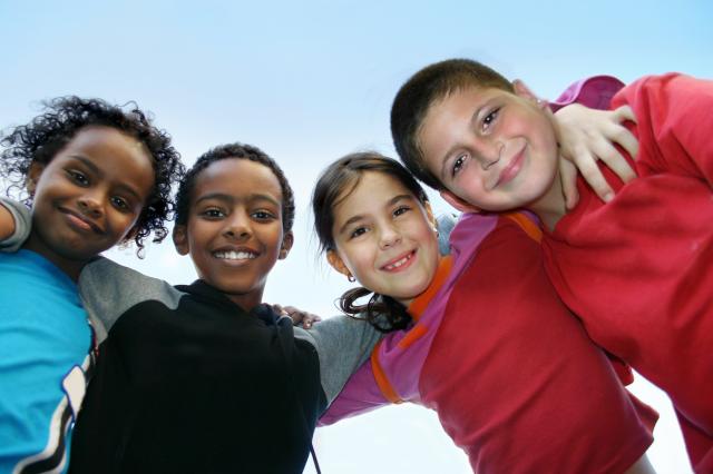 Four smiling children pose for a picture.